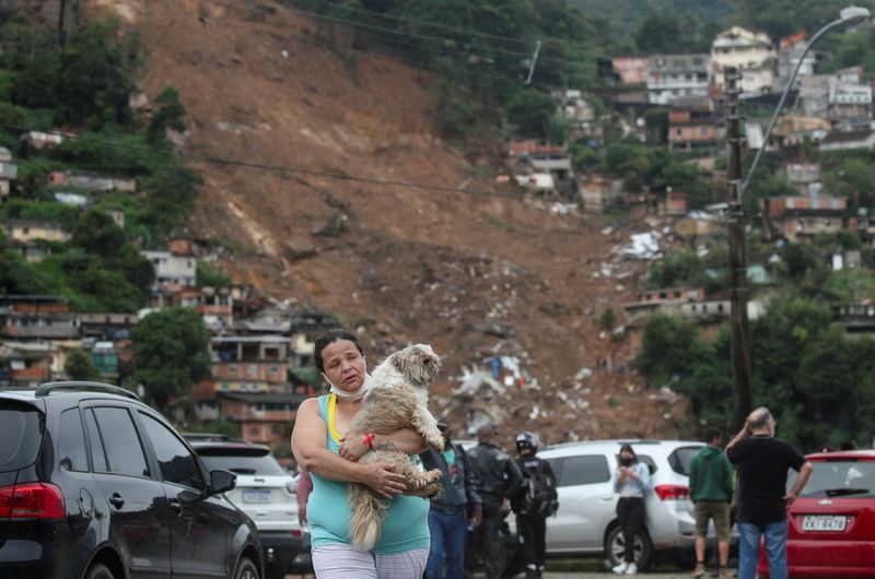 &copy; Reuters. Mulher carrega cachorro em abrigo para pessoas desalojadas por deslizamento de terrra após fortes chuvas em Petrópolis
18/02/2022 REUTERS/Ricardo Moraes