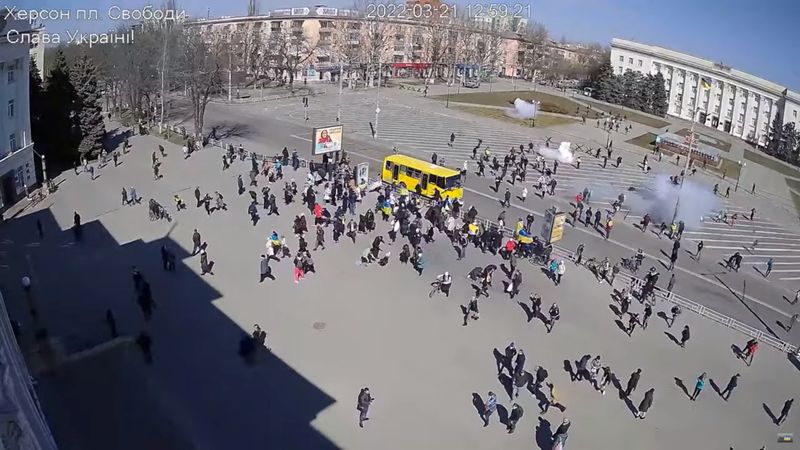 &copy; Reuters. Imagens de CCTV parecem mostrar tropas russas (no topo, perto do prédio) disparando granadas de efeito moral contra manifestantes, alguns com bandeiras ucranianas, em Kherson
21/03/2022
Imagem de vídeo obtido pela REUTERS