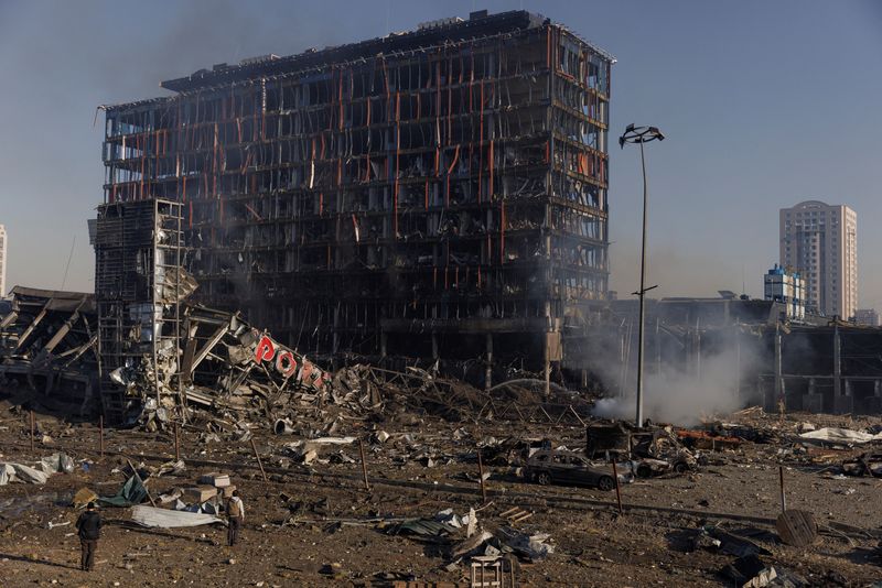 &copy; Reuters. Personas, frente a un centro comercial bombardeado en Kiev, Ucrania, 21 de marzo del  2022.  REUTERS/Thomas Peter