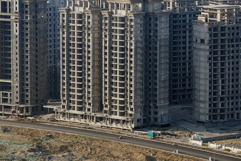 © Reuters. FILE PHOTO: A vehicle travels past some of the 39 buildings developed by China Evergrande Group that authorities have issued demolition order on, on the man-made Ocean Flower Island in Danzhou, Hainan province, China January 6, 2022. REUTERS/Aly Song/File Photo