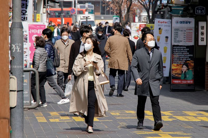 &copy; Reuters. FILE PHOTO: People wearing masks walk in a shopping district amid the coronavirus disease (COVID-19) pandemic in Seoul, South Korea, March 16, 2022. REUTERS/Heo Ran/File Photo/File Photo