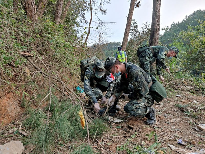 © Reuters. Paramilitary police officers work at the site where a China Eastern Airlines Boeing 737-800 plane flying from Kunming to Guangzhou crashed, in Wuzhou, Guangxi Zhuang Autonomous Region, China March 21, 2022. Picture taken March 21, 2022. China Daily via REUTERS  