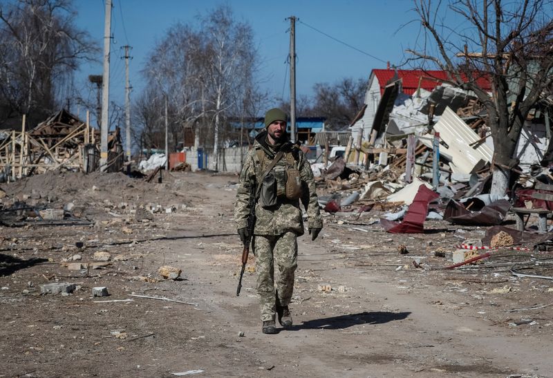 &copy; Reuters. Un membre des services ukrainiens marche dans un village détruit sur la ligne de front dans l'est de la région de Kyiv. Les accusations de Moscou selon lesquelles Kyiv disposent d'armes biologiques et chimiques sont fausses et montrent que le président