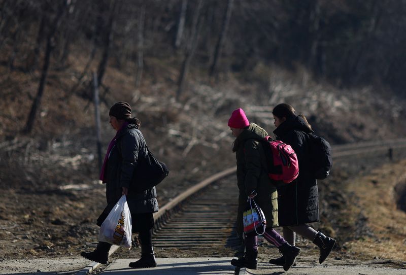 &copy; Reuters. Des réfugiés ukrainiens fuient l'invasion de l'Ukraine par la Russie à pied après avoir traversé la frontière entre l'Ukraine et la Pologne, à Kroscienko, Pologne. Le nombre d'Ukrainiens ayant fui leur pays pour se réfugier à l'étranger s'élèv