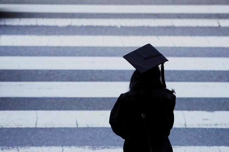 &copy; Reuters. FILE PHOTO: A graduating student waits to cross the street in Cambridge, Massachusetts, U.S., June 7, 2019.   REUTERS/Brian Snyder/File Photo