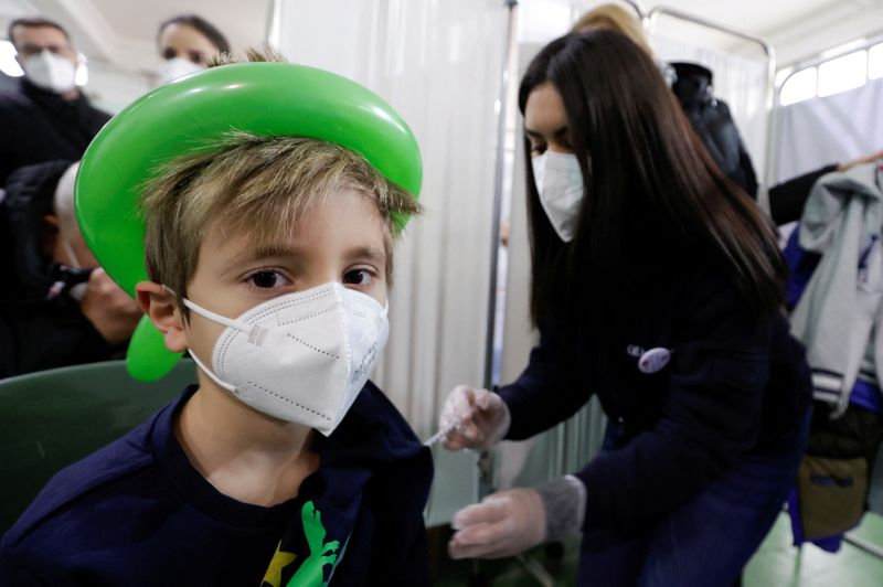 &copy; Reuters. FILE PHOTO: A pupil receives a coronavirus disease (COVID-19) vaccination at a primary school in Naples, Italy, January 12, 2022. REUTERS/Ciro De Luca/File Photo
