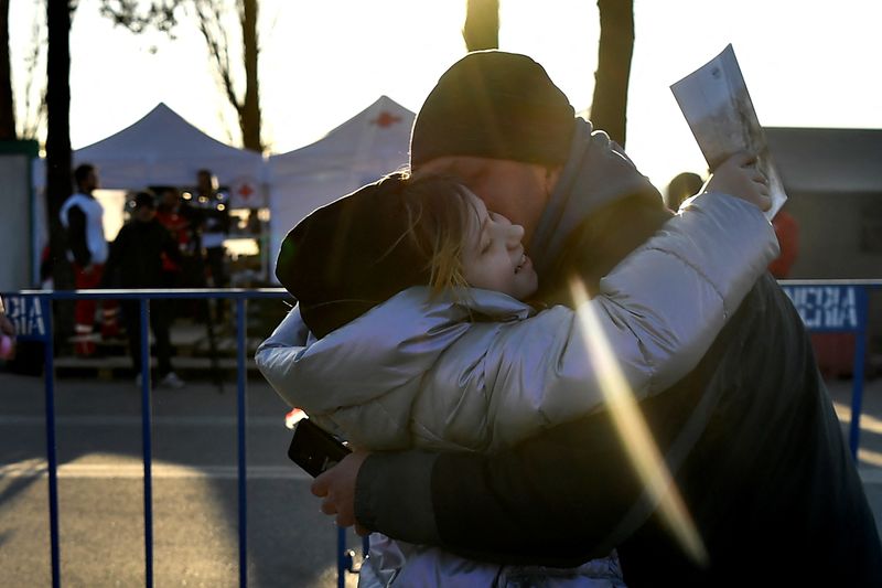 &copy; Reuters. Una joven abraza a su padre tras cruzar la frontera de Ucrania con Rumanía tras haber huído de Járkov ante la invasión rusa, en el puesto fronterizo de Siret, Rumanía, el 21 de marzo de 2022. REUTERS/Clodagh Kilcoyne