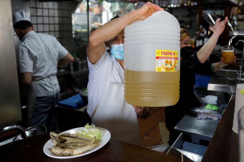 &copy; Reuters. A waiter holds a plastic bottle with sunflower oil used to fry fish at Los Cazadores bar in Ronda, Spain, March 19, 2022. Picture taken March 19, 2022. REUTERS/Jon Nazca