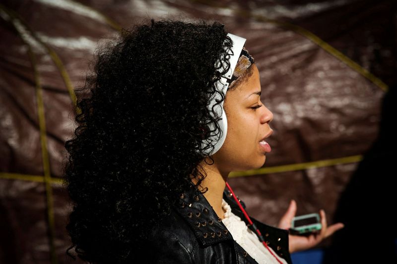 &copy; Reuters. FOTO DE ARCHIVO. Una mujer escucha música a través de sus auriculares mientras camina por una calle de Nueva York, Estados Unidos. 29 de mayo de 2014. REUTERS/Lucas Jackson