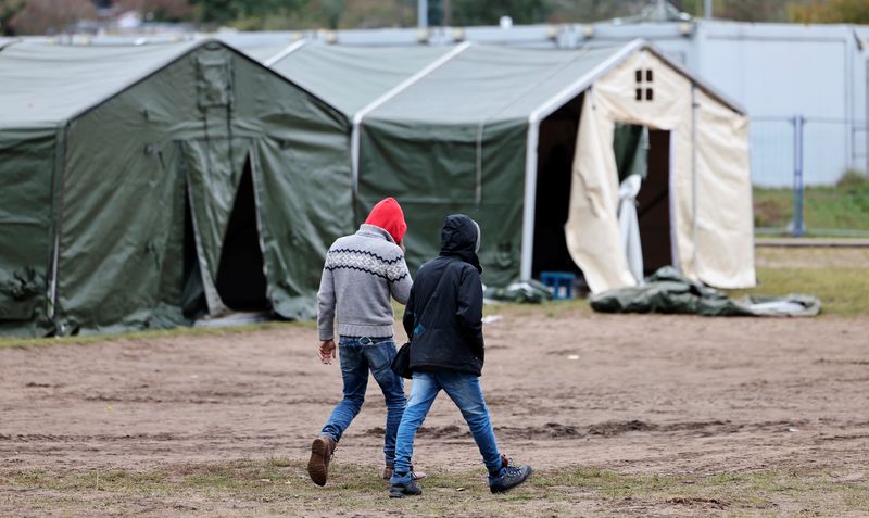 &copy; Reuters. FOTO DE ARCHIVO: Dos personas caminan por un campo de refugiados en Eisenhüttenstadt, Alemania, el 14 de octubre de 2021. REUTERS/Hannibal Hanschke