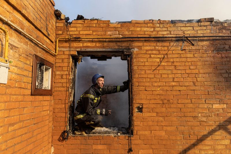 © Reuters. A firefighter works at a residential district that was damaged by shelling, as Russia's invasion of Ukraine continues, in Kyiv, Ukraine March 23, 2022. REUTERS/Marko Djurica 