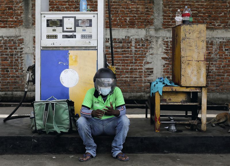 &copy; Reuters. FILE PHOTO: An Uber driver waits at a Ceylon Petroleum Corporation fuel station to buy fuel after his bike ran out of petrol on the road, in Colombo, Sri Lanka March 22, 2022. REUTERS/Dinuka Liyanawatte/File Photo