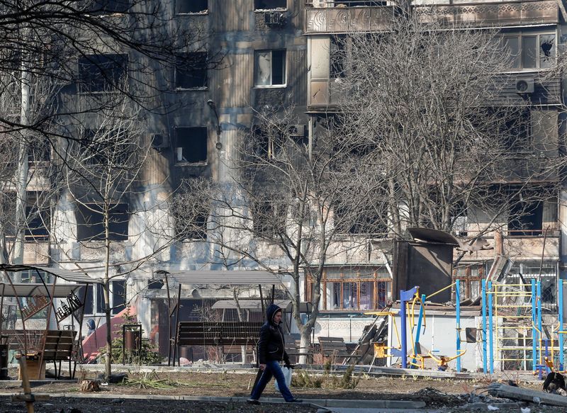 &copy; Reuters. Una mujer camina frente a un edificio destruido por los combates desatados duranta la invasión rusa de Ucrania en Mariúpol, Ucrania, el 23 de marzo de 2022. REUTERS/Alexander Ermochenko
