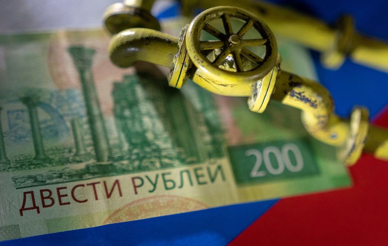 &copy; Reuters. Un modellino di un gasdotto su una banconota da 200 rubli e una bandiera russa March 23, 2022. REUTERS/Dado Ruvic/Illustration