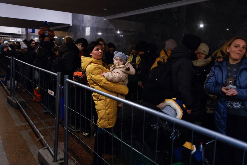 © Reuters. FOTO DE ARCHIVO: Una mujer sostiene un niño mientras personas huyen de la invasión de Rusia a Ucrania en la estación de trenes en Lviv, Ucrania, 21 de marzo del 2022. REUTERS/Zohra Bensemra/Foto de archivo