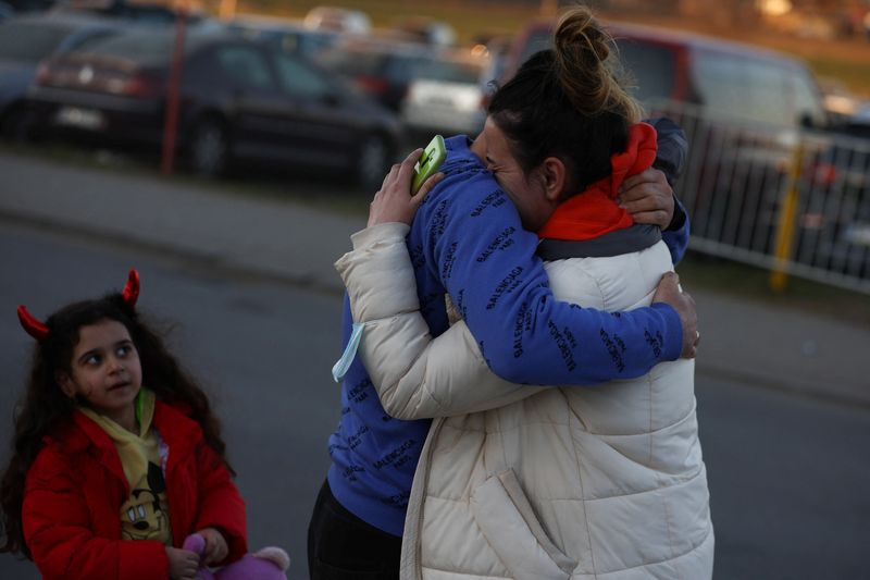 &copy; Reuters. Aysel (33), de Jersón, Ucrania, abraza a su marido mientras su hija Aylin (6) les mira mientras se encuentran, en medio de la invasión rusa de Ucrania, en el paso fronterizo de Medyka, Polonia. 23 de marzo de 2022. REUTERS/Kacper Pempel