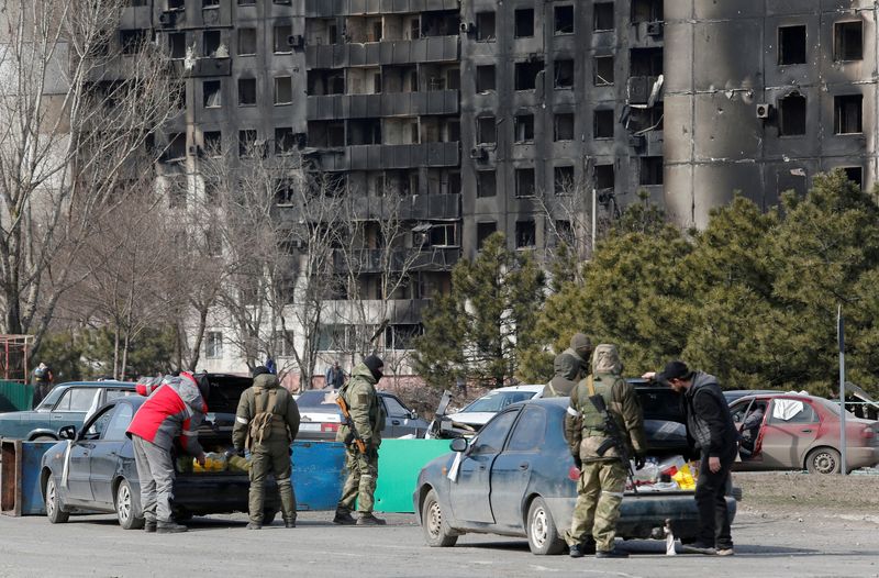 &copy; Reuters. IMAGEN DE ARCHIVO. Miembros de fuerzas prorrusas revisan autos en la sitiada ciudad de Mariúpol, Ucrania. Marzo 20, 2022. REUTERS/Alexander Ermochenko
