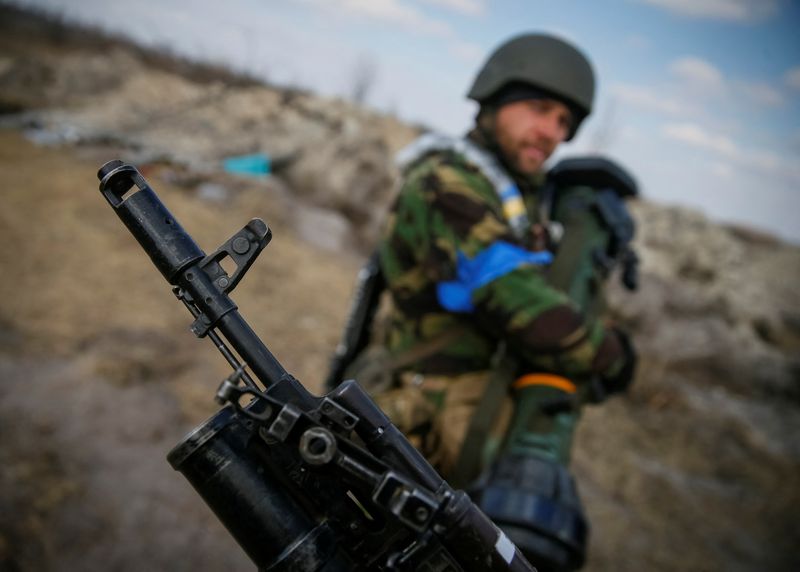 © Reuters. A Ukrainian service member holds a next generation light anti-tank weapon (NLAW) in front of another one holding a rifle at a position on the front line in the north Kyiv region, Ukraine March 24, 2022. REUTERS/Gleb Garanich