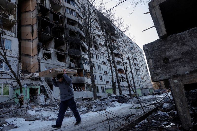 &copy; Reuters. Homem carrega seus pertences após ter sua casa bombardeada durante a invasão russa na cidade ucraniana de Kharkiv
24/03/2022 REUTERS/Thomas Peter