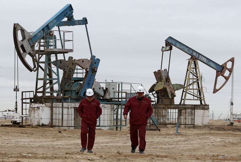 &copy; Reuters. عاملان يسيران أمام مضخات نفطية في قازاخستان في 13 نوفمبر تشرين الثاني 2021. تصوير بافل ميخييف- رويترز.
