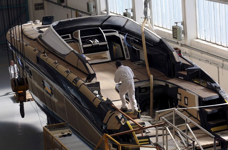 &copy; Reuters. FILE PHOTO: Employees work on a yacht at the Ferretti shipyard in Sarnico, northern Italy, April 7, 2015. REUTERS/Stefano Rellandini