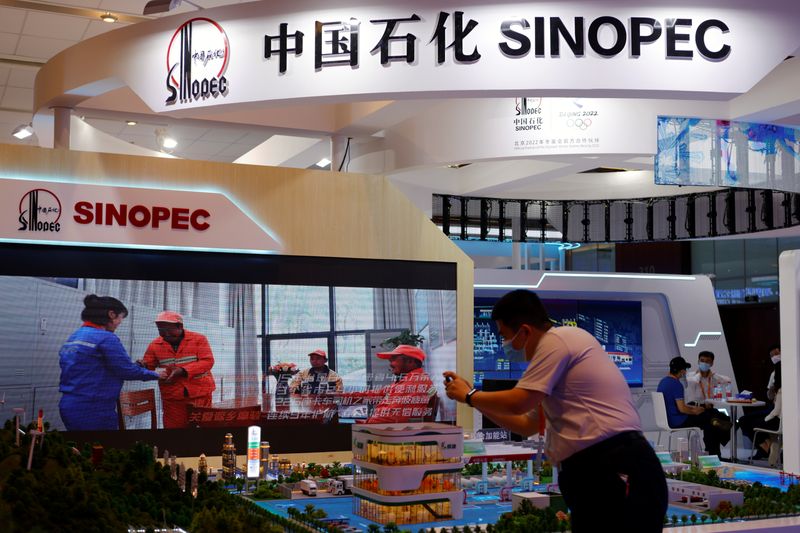 © Reuters. A man takes pictures of models displayed at the Sinopec booth during the 2021 China International Fair for Trade in Services (CIFTIS) in Beijing, China September 4, 2021. REUTERS/Florence Lo