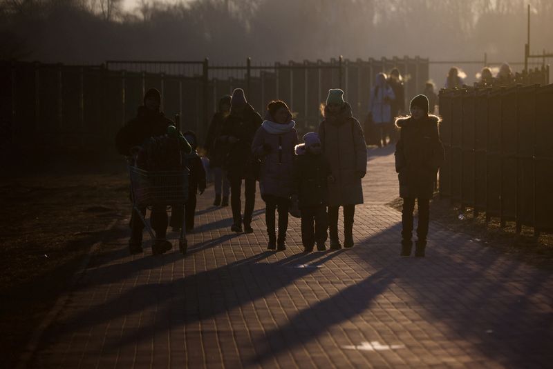 &copy; Reuters. FILE PHOTO: People walk after crossing Polish border, amid Russia's invasion of Ukraine, at the border checkpoint in Medyka, Poland, March 19, 2022. REUTERS/Kacper Pempel   