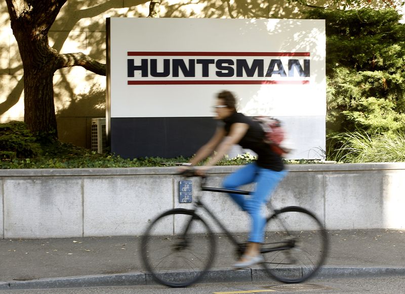 © Reuters. A woman cycles past the logo of U.S. chemical company Huntsman in front of a plant in Basel September 30, 2011.  REUTERS/Arnd Wiegmann 