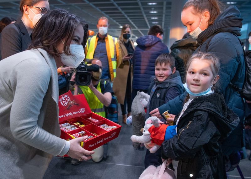 &copy; Reuters. وزيرة الخارجية الألمانية أنالينا بيربوك تقدم حلويات للاجئين أطفال من الأوكرانيين الذين وصلوا إلى مطار فرانكفورت يوم الجمعة. صورة لرويترز م