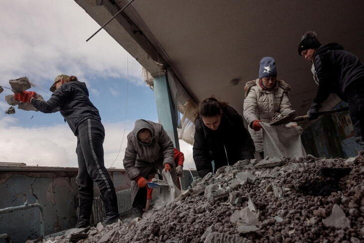 &copy; Reuters. Dos mujeres intentan remover escombros de una escuela dañada por los feroces bombardeos de Rusia en la ciudad de Járkiv, Ucrania. Marzo 27, 2022.  REUTERS/Thomas Peter    
