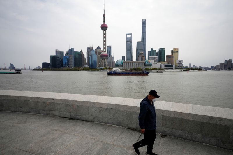 &copy; Reuters. A man walks past Lujiazui financial district, seen across the Huangpu river, amid the lockdown in Pudong area to contain the spread of the coronavirus disease (COVID-19) in Shanghai, China March 28, 2022. REUTERS/Aly Song