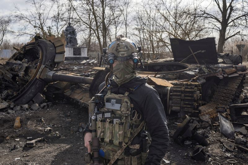 &copy; Reuters. Un soldado ucraniano camina frente a un tanque ruso destruido en la aldea de Lukyanivka, a las afueras de Kiev, Ucrania, el 27 de marzo de 2022. REUTERS/Marko Djurica
