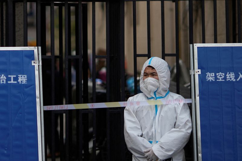 &copy; Reuters. Un trabajador sanitario con un equipo de protección individual tras la barrera de un área confinada por causa de la pandemia de COVID-19 en Shanghái, China, el 26 de marzo de 2022. REUTERS/Aly Song