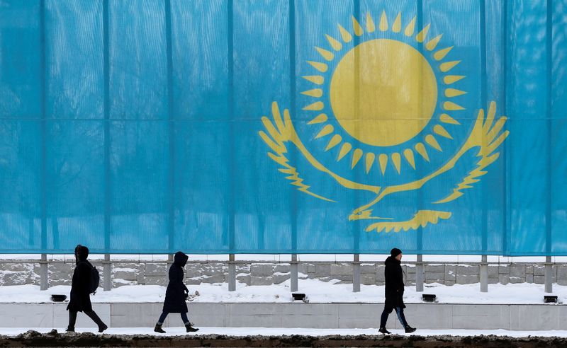 &copy; Reuters. FOTO DE ARCHIVO: Varias personas pasan frente a la bandera de Kazajistán en Astaná, Kazajistán, el 5 de marzo de 2019. REUTERS/Pavel Mikheyev