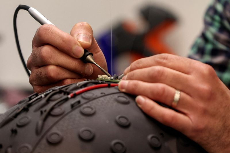 &copy; Reuters. A worker at the Israeli startup Brain.Space builds an electroencephalogram (EEG) enabled helmet, due to be used in an experiment on the impact of a microgravity environment on the brain activity of astronauts, in Tel Aviv, Israel, March 23, 2022. Picture 