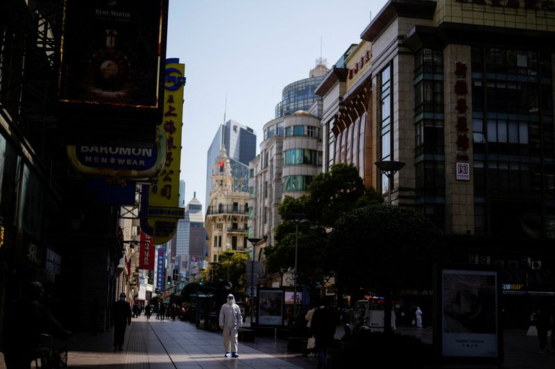 © Reuters. A security guard in personal protective equipment (PPE) walks at a main shopping area following the coronavirus disease (COVID-19) outbreak in Shanghai, China March 29, 2022. REUTERS/Aly Song   