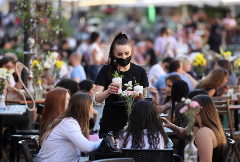 &copy; Reuters. A waiter serves drinks to customers at a restaurant in Campo de' Fiori, in Rome, Italy, June 4, 2021. REUTERS/Yara Nardi