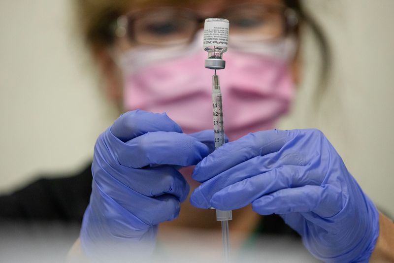 © Reuters. FILE PHOTO: A nurses fills up syringes for patients as they receive their coronavirus disease (COVID-19) booster vaccination during a Pfizer-BioNTech vaccination clinic in Southfield, Michigan, U.S., September 29, 2021.  REUTERS/Emily Elconin