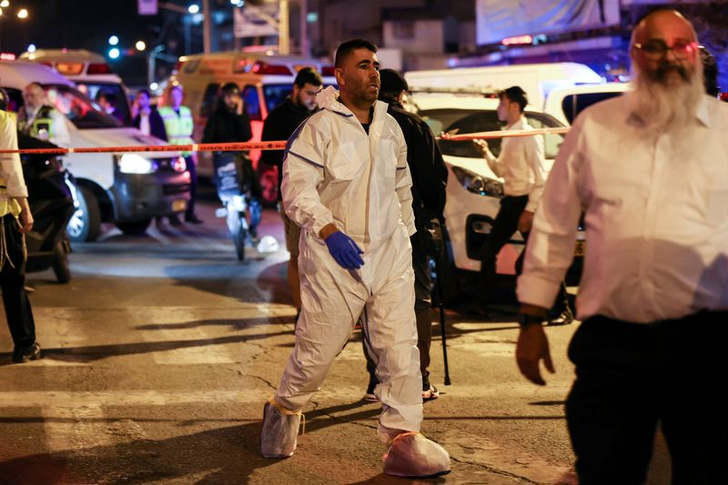 © Reuters. خبراء الطب الشرعي في الشرطة الإسرائيلية يعملون في موقع الهجوم الذي شهده ضاحية بني براك بتل أبيب يوم الثلاثاء. تصوير: نير إلياس-رويترز.