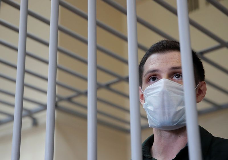 &copy; Reuters. FILE PHOTO: Former U.S. Marine Trevor Reed, who was detained in 2019 and accused of assaulting police officers, stands inside a defendants' cage during a court hearing in Moscow, Russia July 30, 2020. REUTERS/Maxim Shemetov/File Photo