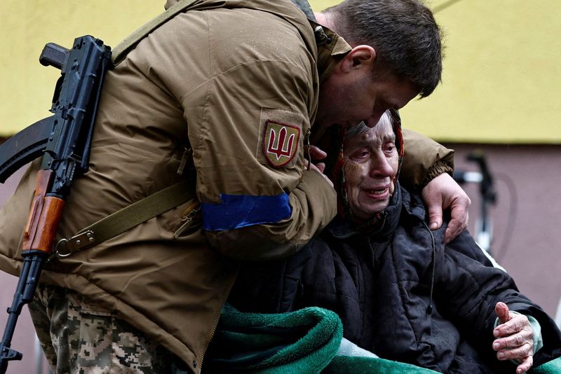 © Reuters. جندي أوكراني يحتضن والدته لدى إجلائها من اربين لدى استمرار القصف الروسي يوم الأربعاء. تصوير زهرة بنسمرة- رويترز.