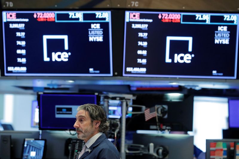 © Reuters. A trader walks below screens showing the current price of Intercontinental Exchange (ICE) on the floor of the New York Stock Exchange (NYSE) in New York, U.S., March 20, 2020.  REUTERS/Lucas Jackson