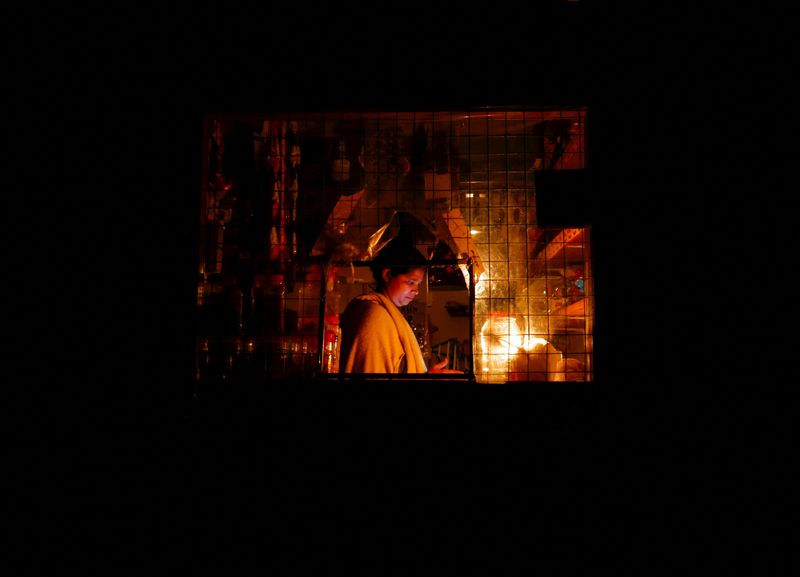 © Reuters. A woman works inside a shop attached to her house during the power cut in Colombo, Sri Lanka  March 30, 2022. REUTERS/Dinuka Liyanawatte