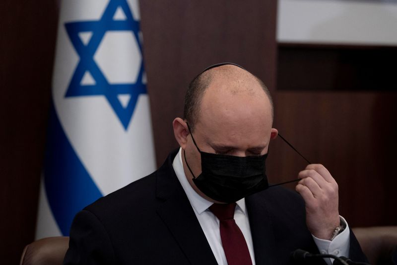 &copy; Reuters. FILE PHOTO: Israeli Prime Minister Naftali Bennett removes his mask at the start of the weekly cabinet meeting in Jerusalem, March 20, 2022. Maya Alleruzzo/ Pool via REUTERS