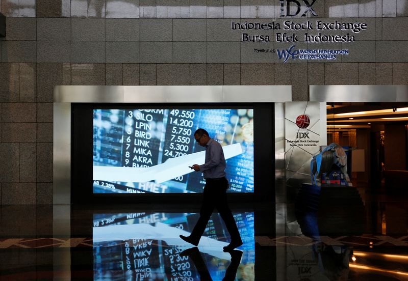 &copy; Reuters. FILE PHOTO: A man walks past screen at the Indonesia Stock Exchange building in Jakarta, Indonesia, September 6, 2018. REUTERS/Willy Kurniawan