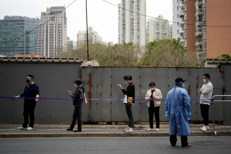 &copy; Reuters. People practise social distancing as they line up behind a cordon to buy food, following the coronavirus disease (COVID-19) outbreak in Shanghai, China March 30, 2022. REUTERS/Aly Song