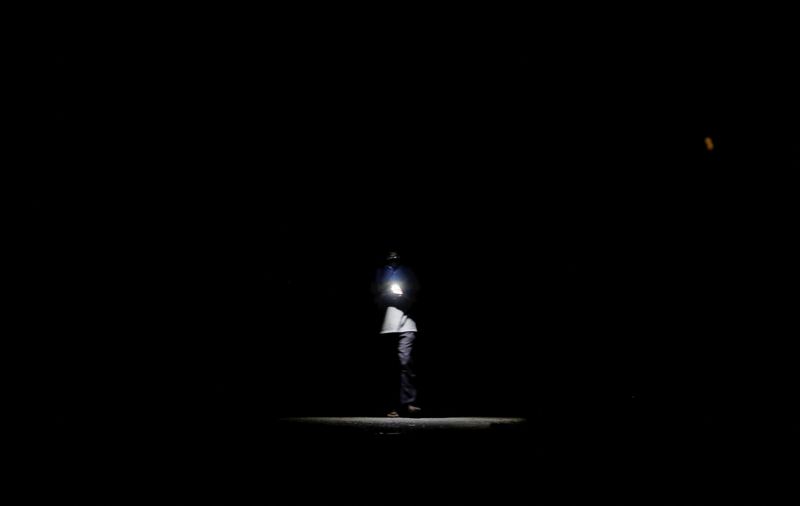 &copy; Reuters. A man walks along a road using his mobile phone's torch light during the power cut in Colombo, Sri Lanka March 30, 2022. REUTERS/Dinuka Liyanawatte
