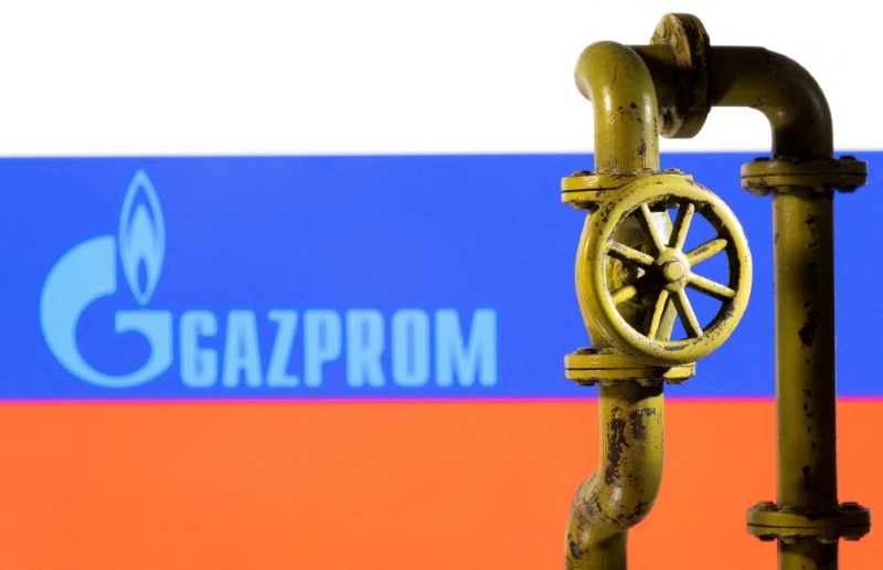 &copy; Reuters. Il logo Gazprom impresso su una bandiera russa davanti a una miniatura di un gasdotto . REUTERS/Dado Ruvic/