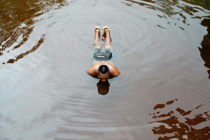 © Reuters. A man bathes in a stream near Block 192, a dormant Amazon oil field with a history of environmental spills where Peru is looking to reboot production amid soaring global crude prices linked to Russia's invasion of Ukraine, in Nuevo Andoas, Peru February 22, 2022. Picture taken February 22, 2022. REUTERS/Alessandro Cinque