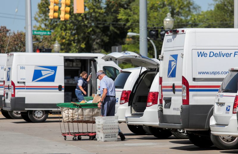 &copy; Reuters. FILE PHOTO: United States Postal Service (USPS) workers load mail into delivery trucks outside a post office in Royal Oak, Michigan, U.S. August 22, 2020. REUTERS/Rebecca Cook/File Photo